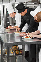 Image showing Chefs Garnishing Pasta Dishes