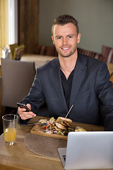 Image showing Businessman With Mobilephone And Laptop Having Meal In Restauran
