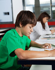 Image showing Schoolboy Studying At Desk In Classroom