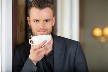 Image showing Young Business man Holding Coffee Cup At Cafe