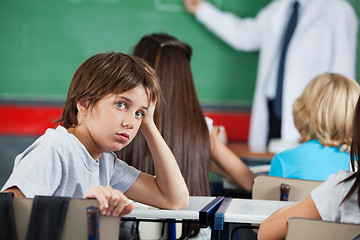 Image showing Portrait Of Little Boy Leaning At Desk