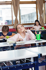 Image showing Schoolgirl Looking Up With Digital Tablet At Desk