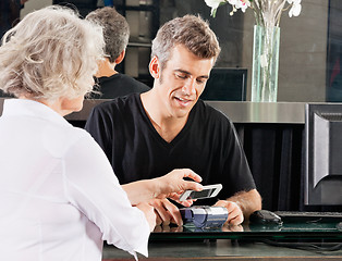 Image showing Customer Paying Through Mobile Phone At Salon