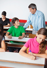 Image showing Teacher And Teenage Boy Looking At Each Other During Examination