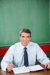 Image showing Professor With Binder And Pen Sitting At Desk