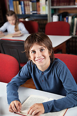 Image showing Schoolboy With Book Sitting In Library