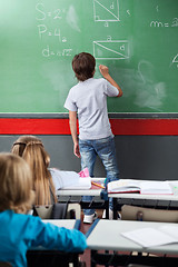 Image showing Schoolboy Solving Mathematics On Board