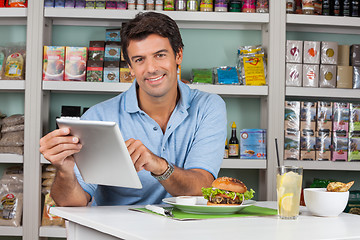 Image showing Male Customer With Snacks Using Digital Tablet In Supermarket