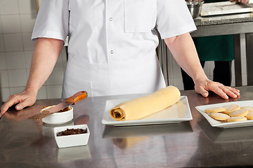 Image showing Female Chef With Chocolate Roll On Counter