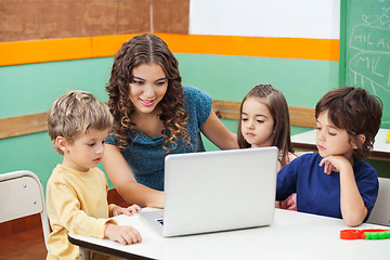 Image showing Teacher And Students Using Laptop In Class