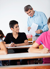 Image showing Teacher And Teenage Schoolboy Looking At Paper