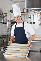 Image showing Male Chef Presenting Baked Bread Loafs