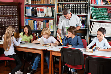 Image showing Teacher Showing Book To Schoolboy In Library