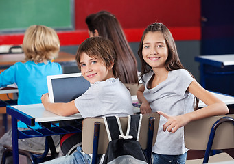 Image showing Schoolchildren With Digital Tablet Sitting In Classroom