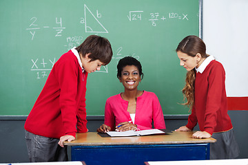 Image showing Teacher With Students At Desk