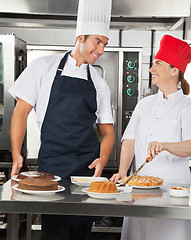 Image showing Happy Chefs Preparing Sweet Dishes in Kitchen