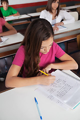 Image showing Teenage Schoolgirl Writing At Desk