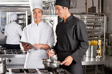 Image showing Chef Assisting Colleague In Preparing Food