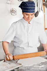 Image showing Female Chef Rolling Dough On Counter