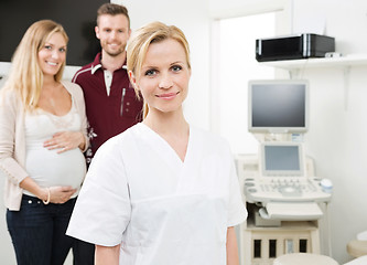 Image showing Confident Doctor With Expectant Couple In Background