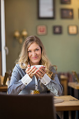 Image showing Young Woman With Coffee Cup At Table