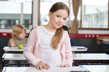 Image showing Little Girl Studying While Standing At Desk