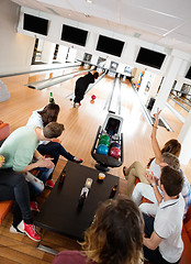 Image showing Friends Cheering Woman Bowling in Club