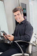 Image showing Male Customer With Digital Tablet Sitting At Salon