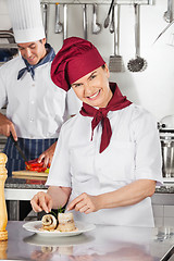 Image showing Female Chef Garnishing Salmon Roll