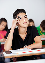 Image showing Thoughtful Teenage Schoolboy Leaning At Desk