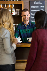 Image showing Young Bartender Serving Coffee To Female Friends At Coffeeshop