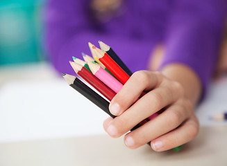 Image showing Girl Holding Colored Pencils At Desk