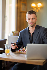 Image showing Businessman With Mobilephone And Laptop Having Food