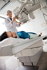 Image showing Radiologist Setting Up Machine To X-ray Female