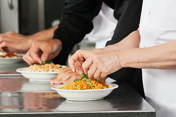 Image showing Chefs Garnishing Pasta Dishes