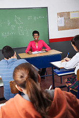 Image showing Female Teacher Sitting With Students In Classroom