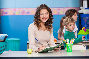 Image showing Teacher Writing In Book