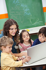 Image showing Teacher And Students Using Laptop In Class