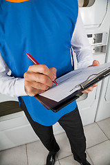 Image showing Young Male Helper Checking List In Laundry