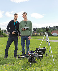 Image showing Engineers Standing By UAV Helicopter And Tripod