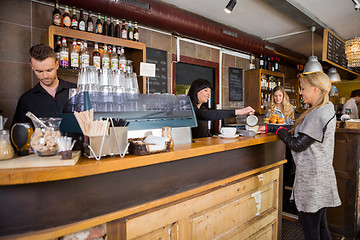 Image showing Female Bartender Serving Coffee To Customer At Counter