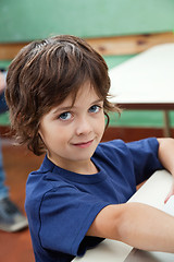 Image showing Little Boy Smiling At Desk