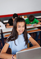 Image showing Happy Teenage Schoolgirl Sitting With Laptop At Desk