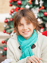 Image showing Boy Smiling Against Christmas Tree