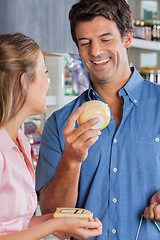 Image showing Couple Choosing Cheese At Grocery Store