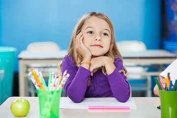 Image showing Thoughtful Girl With Hand On Chin Sitting At Desk