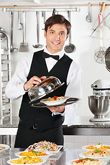 Image showing Waiter Lifting The Cover Of Cloche