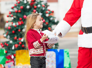 Image showing Santa Claus Taking Wish List From Girl