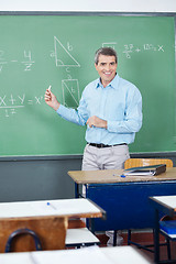 Image showing Male Teacher Teaching Mathematics On Board