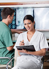 Image showing Female Medical Technician Holding Clipboard